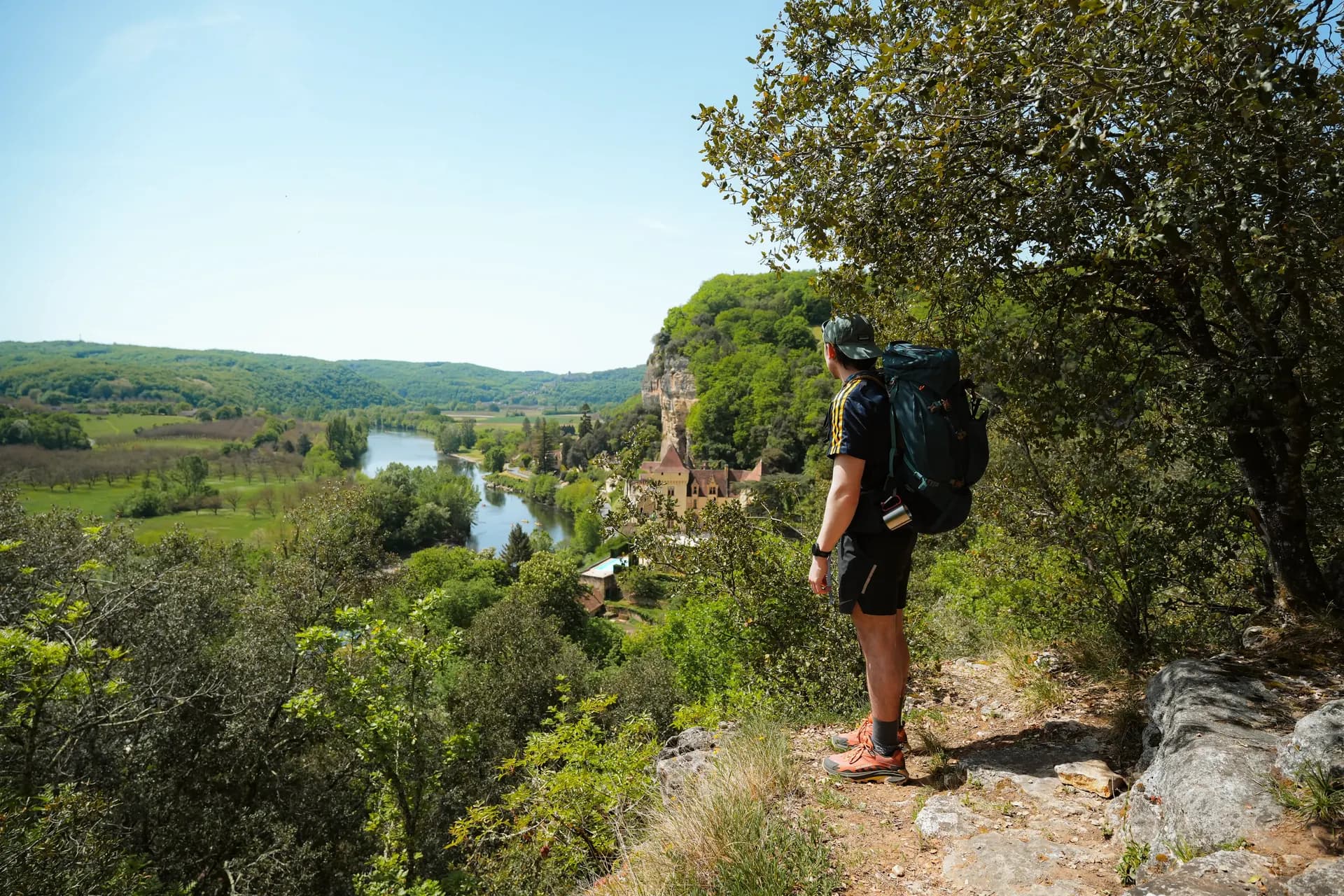 Randonneur avec vue sur chateau sur la Dordogne